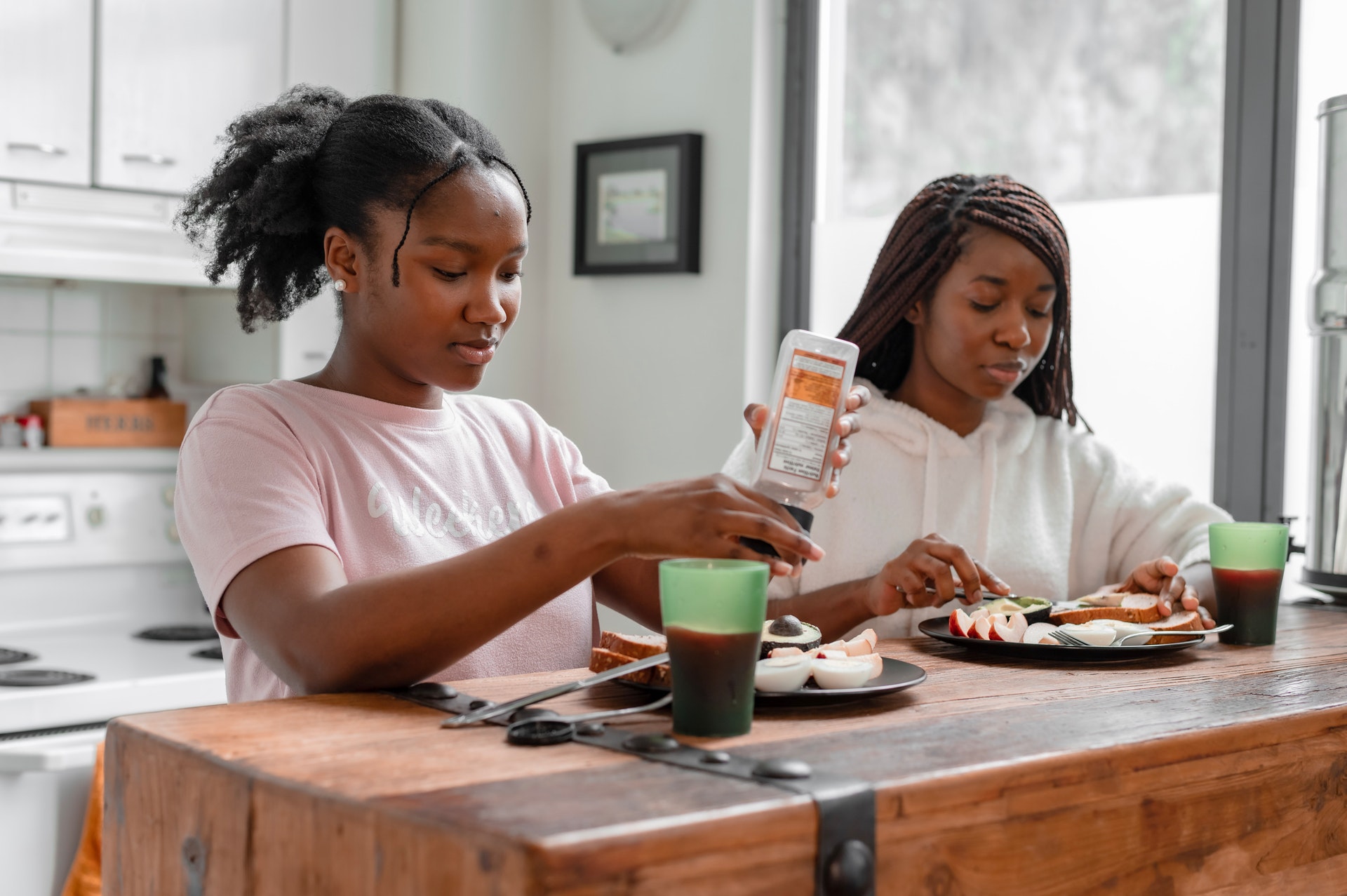 Two teenage women making themselves a nutritious lunch at home.